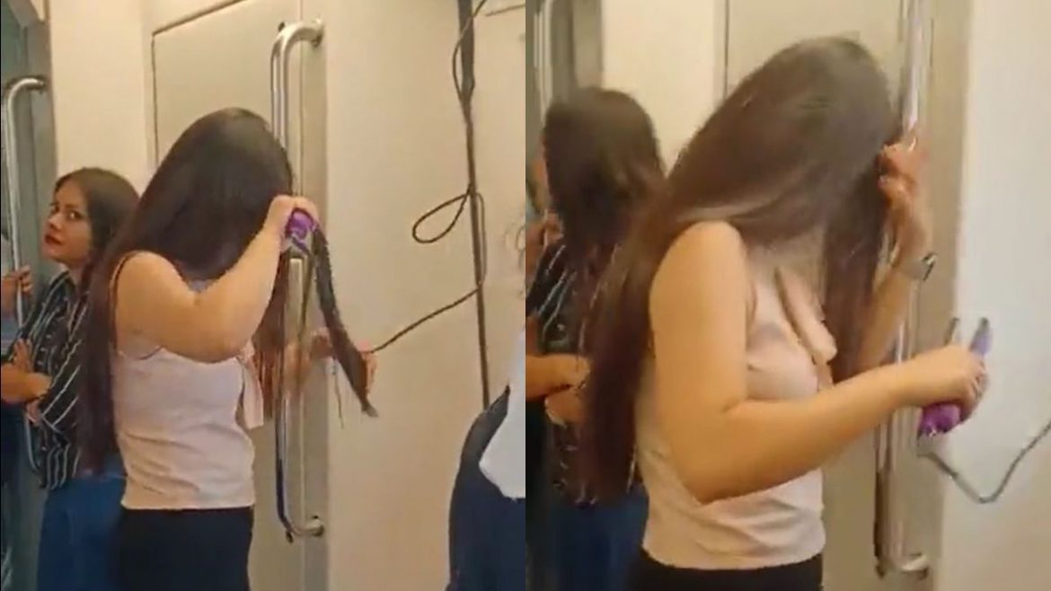 A Woman Straightens Her Hair Inside The Delhi Metro
